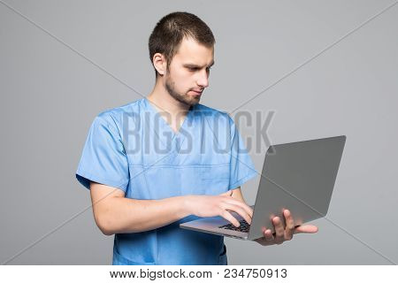 The Doctor Staring On The Laptop Isolated On Gray