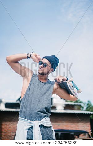 Handsome Skater Posing With Lonboard And Looking Away