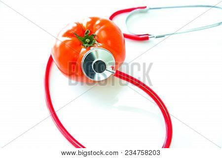Abstract Healthy Concept, Selective Focus On Stethoscope Is Checking A Big Tomato With White Backgro