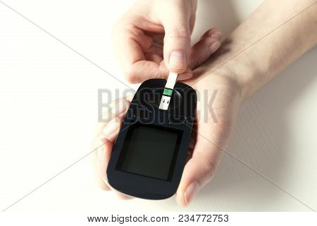 Diabetes Checking Blood Sugar Level. Woman Using Lancelet And Glucometer At Home