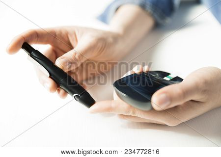 Diabetes Checking Blood Sugar Level. Woman Using Lancelet And Glucometer At Home