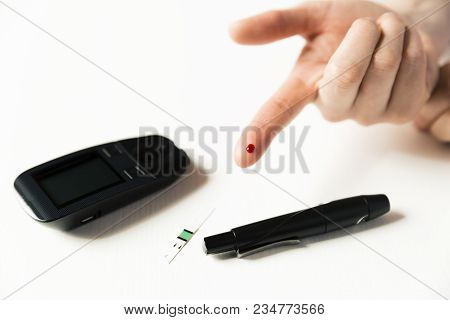 Diabetes Checking Blood Sugar Level. Woman Using Lancelet And Glucometer At Home