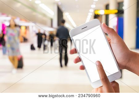 Mobile Phone Held In One Hand Showing Finger Touch On Screen Display Over Blur Shopping Store Backgr