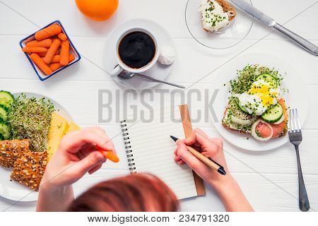 Morning Habits Of Successful People. Day Planning And Healthy Meal. Woman Eating Carrot And Writing 