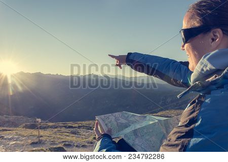 Female Traveler Showing The Way. Sunset In Spectacular Mountains.