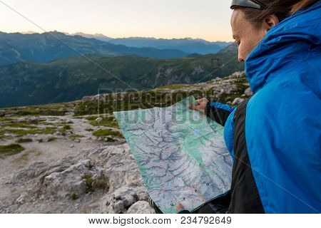Female Trekker Studying A Map. Exploring Brenta Dolomites,