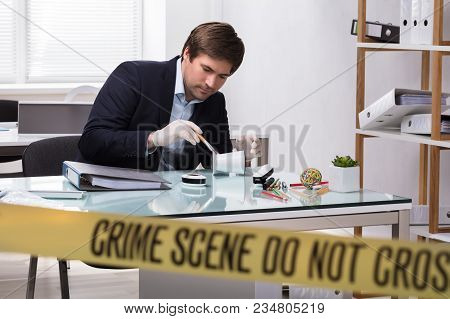 Forensic Expert Searching For Crime Evidence On Pencil Holder Behind Crime Scene Tape