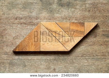 Tangram Puzzle In Parallelogram Shape On Wood Background