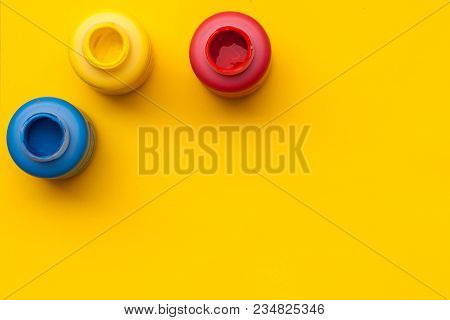 Red, Yellow Nad Blue Paint Bottels On Yellow Background With Copy Space, Top View/romania National D