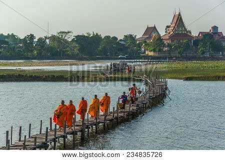 Maha Sarakham, Thailand - December 20, 2015: Buddhist Monks Marching To Seek Alms  While Merchant Wa