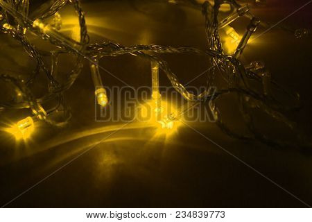 Yellow Garland Lights On Black Background. Macro