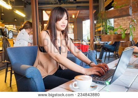 Business Women Working With Laptop In Cafe And Drink Latteart