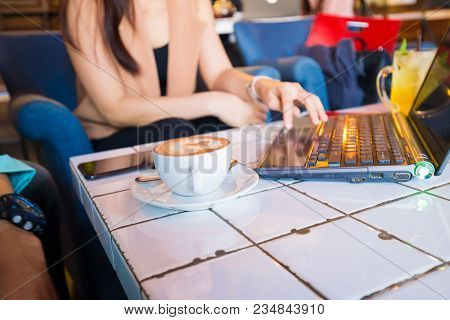 Business Women Working With Laptop In Cafe And Drink Latteart