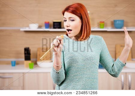 Happy Redhead Woman In The Kitchen Singing