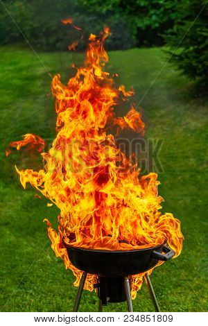 A Big Fire Flashover A Black Grill Outdoors When Having A Barbeque.