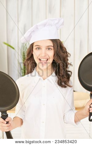 Young Female Chef With Two Pancake Pans.
