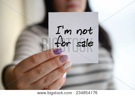 Young Sad Girl Shows A White Sticker. Caucasian Brunette Holding