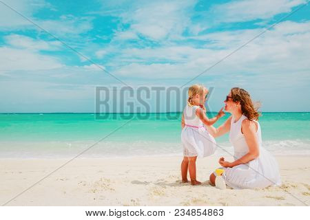 Mother And Daugghter Applying Sunblock Cream On Beach, Sun Protection