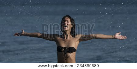 Girl In Little Bra Stand In Sea Water Making Splashes Of Water With Hands. Vacation Concept. Slim Se