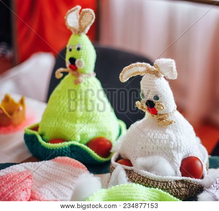 Three Handmade Knitted Hens And Rabbits On Beige Background As Easter Decoration