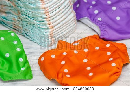 Stack Of Disposable Diapers Or Nappies And Colorful Reusable, Parenthood Concept