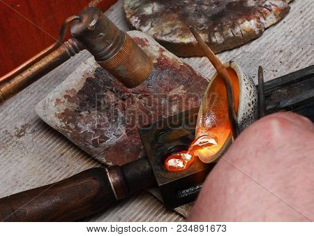 The Work Of A Jeweler. Close-up Of Pouring Molten Gold Into A Mold For Solidification.