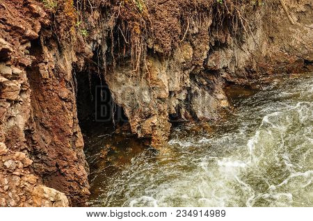 Grotto In A Red Rock On A Mountain River. Altai, Russia.