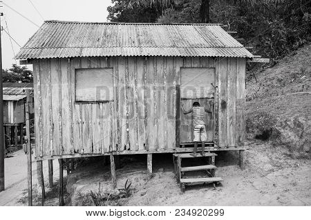 Boca De Valeria, Brazil - December 03, 2015: Hut On Piles And Boy Child In Village On Mud Background