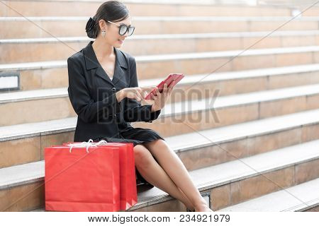 Attractive And Exusive Business Woman Wearing Modern Sunglass With Lot Of Red Shopping Bags. Happy A