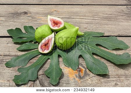 Halved Fig On Figs And Fig Leafs,wood Board As Background, Copy Space