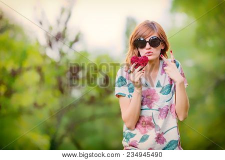 Cute Young Woman Holding A Heart - Shaped Sign Outdoors.