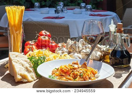 Sunlit Plate Of Italian Pasta With Basic Ingredients Around