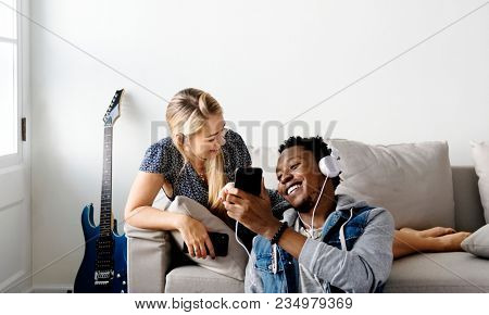 Interracial couple sharing music at home love, leisure and music concept