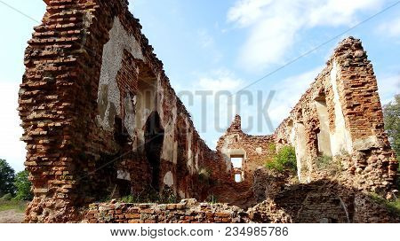 An Old Broken Brick Wall With Cracks. Ruined Wall Of The Old Cathedral.