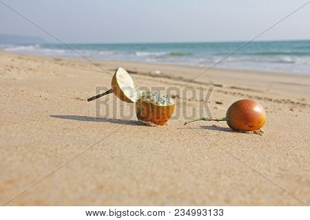 Two Orange Open Passion Fruit With Seeds. Passion Fruit Closeup On The Beach, On The Sand And On The