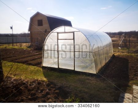 Polycarbonate Greenhouse Stands On A Garden Plot In The Daytime