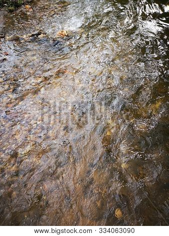 View of the pebbles at the bottom through the rapid flow of the river