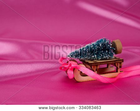 Christmas Tree On A Sledge On A Background Of Shiny Pink Satin As Background, Silk Background, Chris