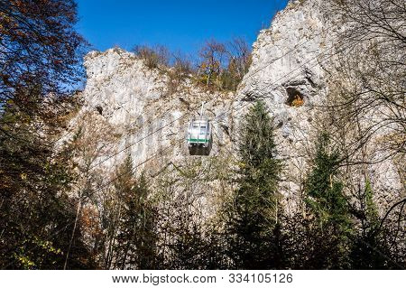 Cableway With Blue Sky And Rocks Background. Cable Cabin In Moravia. Macocha Cable Tramway. Translat