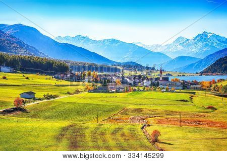 Magnificent Autumn View Of St.valentin Village And Haidersee (lago Della Muta) Lake With Ortler Peak