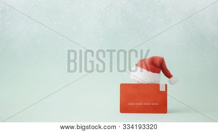 Christmas Shopping Idea Concept Background. Credit Card And Santa Claus Hat On Bokeh Background.