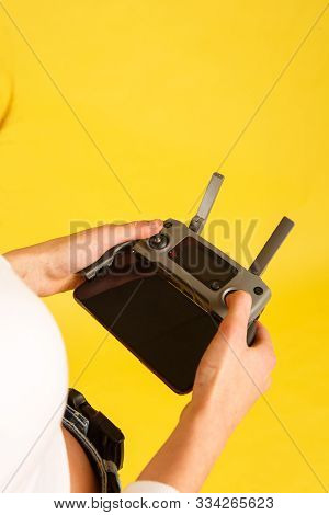 Teen Girl Launches Aerial Drone Quadcopter. Isolated On A Yellow Background. Aerial Photography.