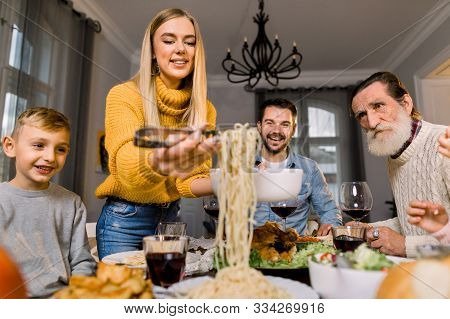 Happy Smiling Family, Grandfather, Parents And Children Sitting At Festive Table And Eating Tasty Di