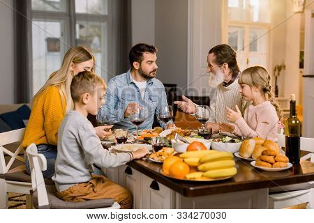 Family With Kids Eating Thanksgiving Dinner. Roasted Turkey And Pasta, Salad And Fruits On Dining Ta