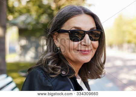 Cheerful Beautiful Mature European Female In Her Fifty Enjoying The Nice Summer Weather Outdoors, Si
