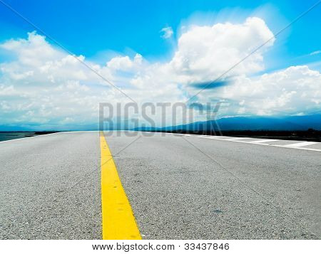 Strada con linee gialle sul cielo e nuvole