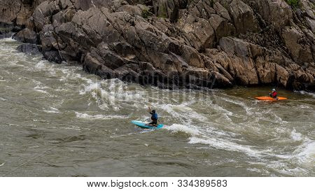 Two Men On Kayaks Paddlying On The River At Great Falls National Park, Virginia
