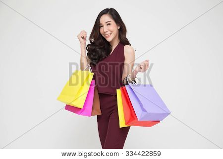 Portrait Of A Happy Young Women In Red Dress Holding Shopping Bags Isolated Over White Background, Y
