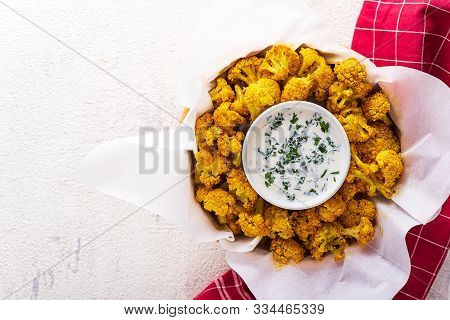 Vegetarian Baked Cauliflower With Breadcrumbs And Spices With Sour Cream Sauce And Greens On White B