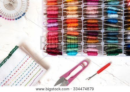 Set Of Multi-colored Cotton Threads And Fragment Of Colorful Cross-stitch Embroidere. Colorful Mouli